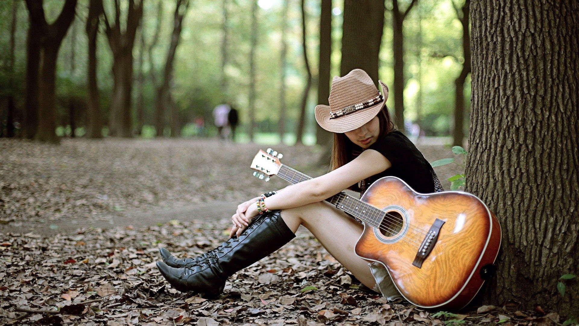 Bức hình cô gái buồn chất bên cây đàn guitar