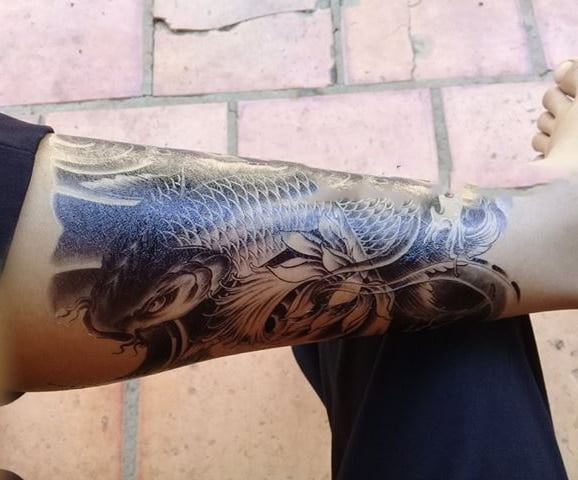 Cá chép hoa sen xăm nghệ thuật ở bắp chân