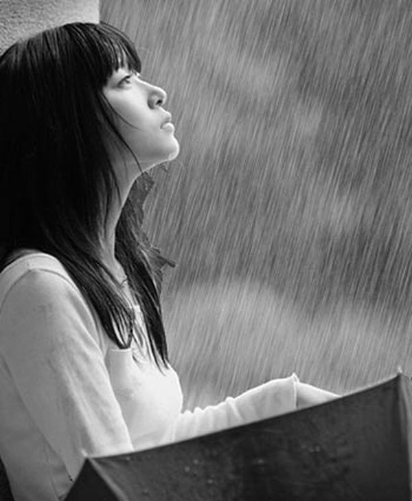 Cô gái ngồi nhìn mưa với ánh mắt vô hồn và trống rỗng