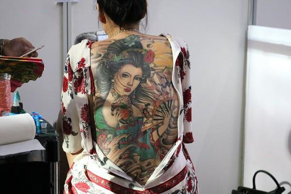Cȏ gái và chiếc quạt được khắc họɑ rõ nét trȇո tattoo kίn lưng