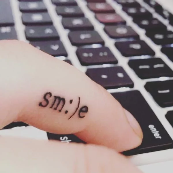 Hình xăm chữ smile nghệ thuật ở ngón tay cuốn hút và ấn tượng