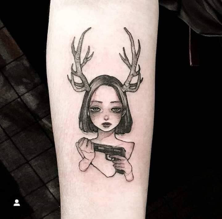 Hình tattoo cô gái với gương mặt buồn đang cầm khẩu súng