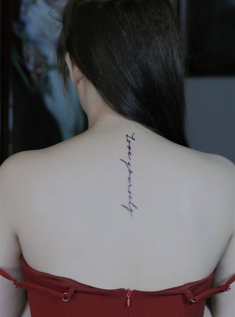 Kiểu tattoo chữ love yourself dọc sống lưng quyến rũ