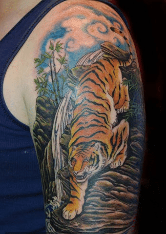 Kiểu tattoo hổ xuống núi có màu nghệ thuật ở bắp tay