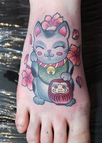 Nhẹ nhàng và nữ tính với kiểu tattoo mèo thần tài và daruma ở chân