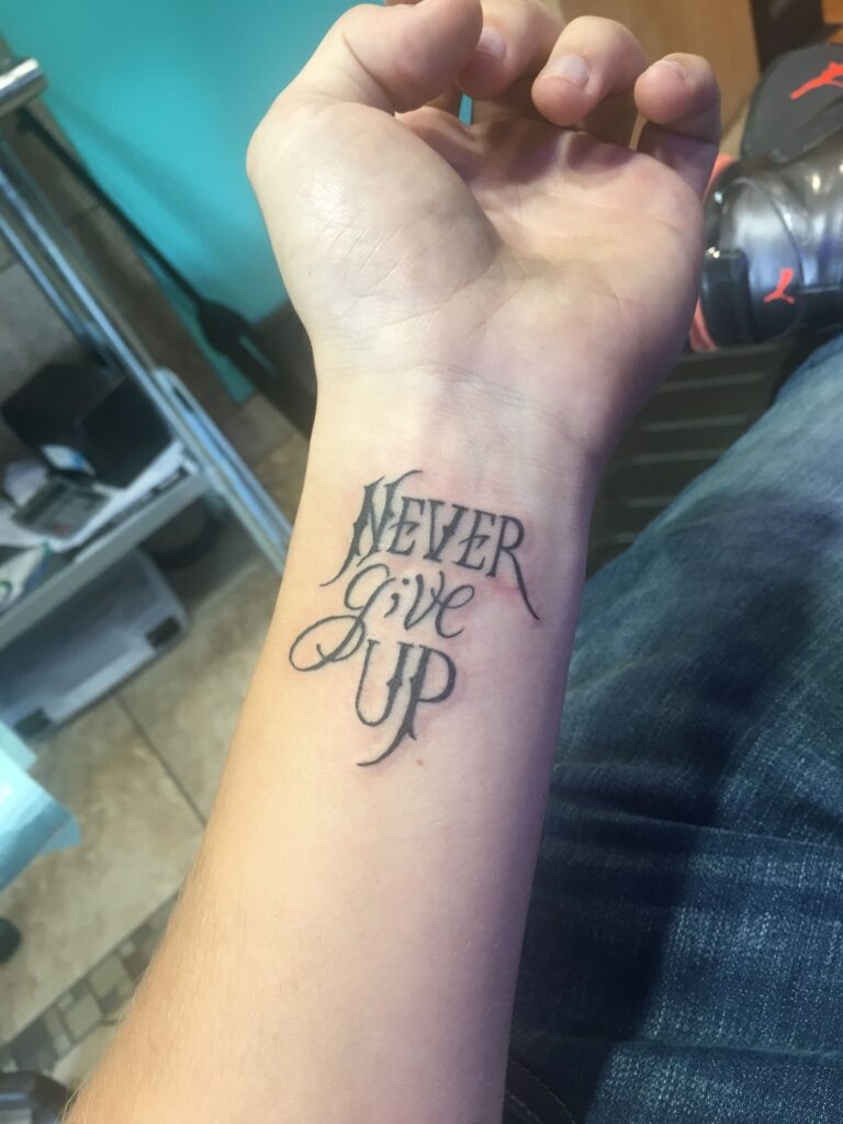 Tattoo xăm Never Give Up trên tay ý nghĩa